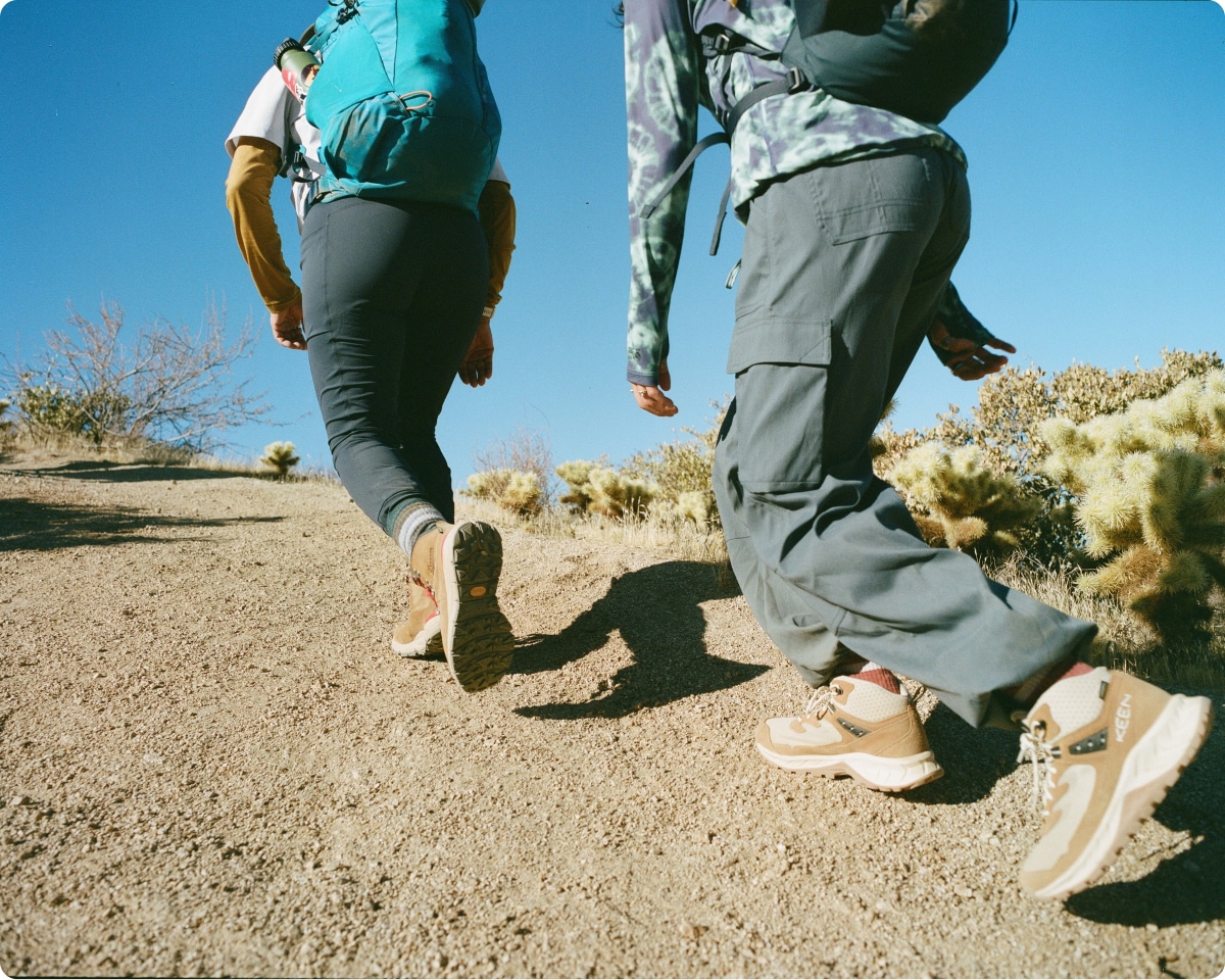 Two hikers head uphill wearing KEEN Hightrail Mid Waterproof HIking Boots.