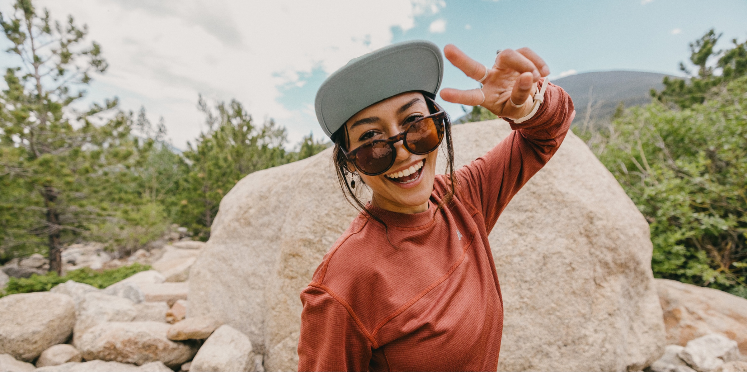 A hiker poses for the camera on a mountain trail.