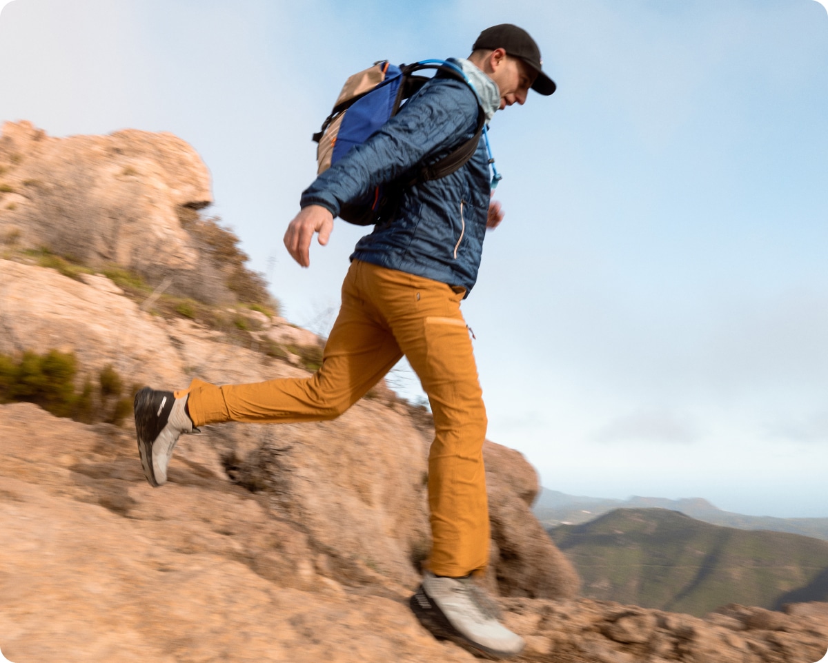 A person hikes down a rocky trail.