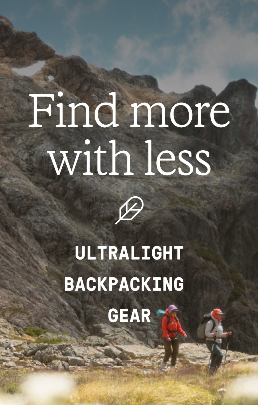 Text reads: ‘Find more with less. Ultralight backpacking gear’ over an image of two people trekking through rocky terrain.