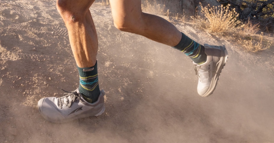 A person kicks up dust while running outdoors.