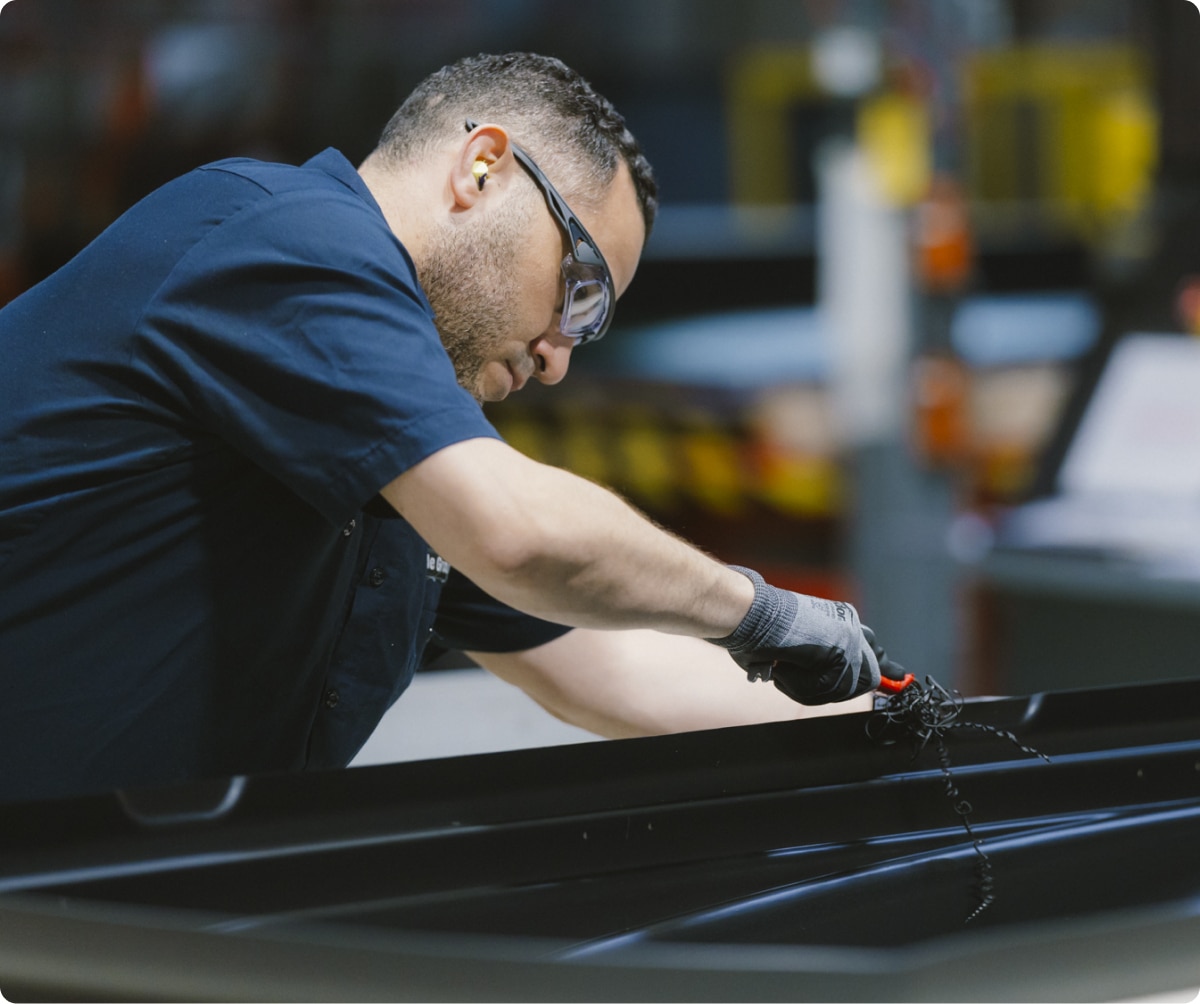 A worker assembles a Thule product.