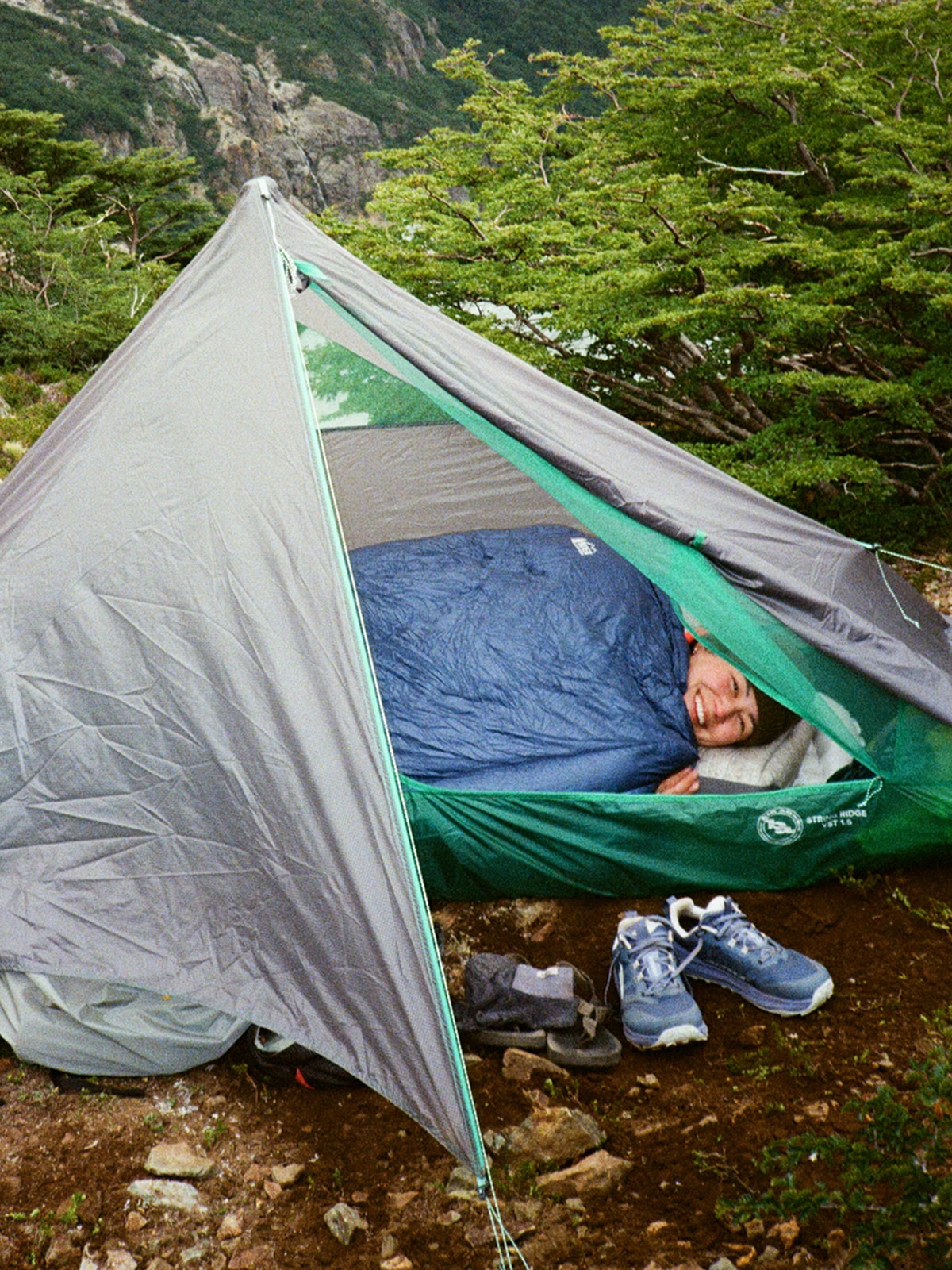 A person smiles for the camera while laying down in their Big Agnes tent.
