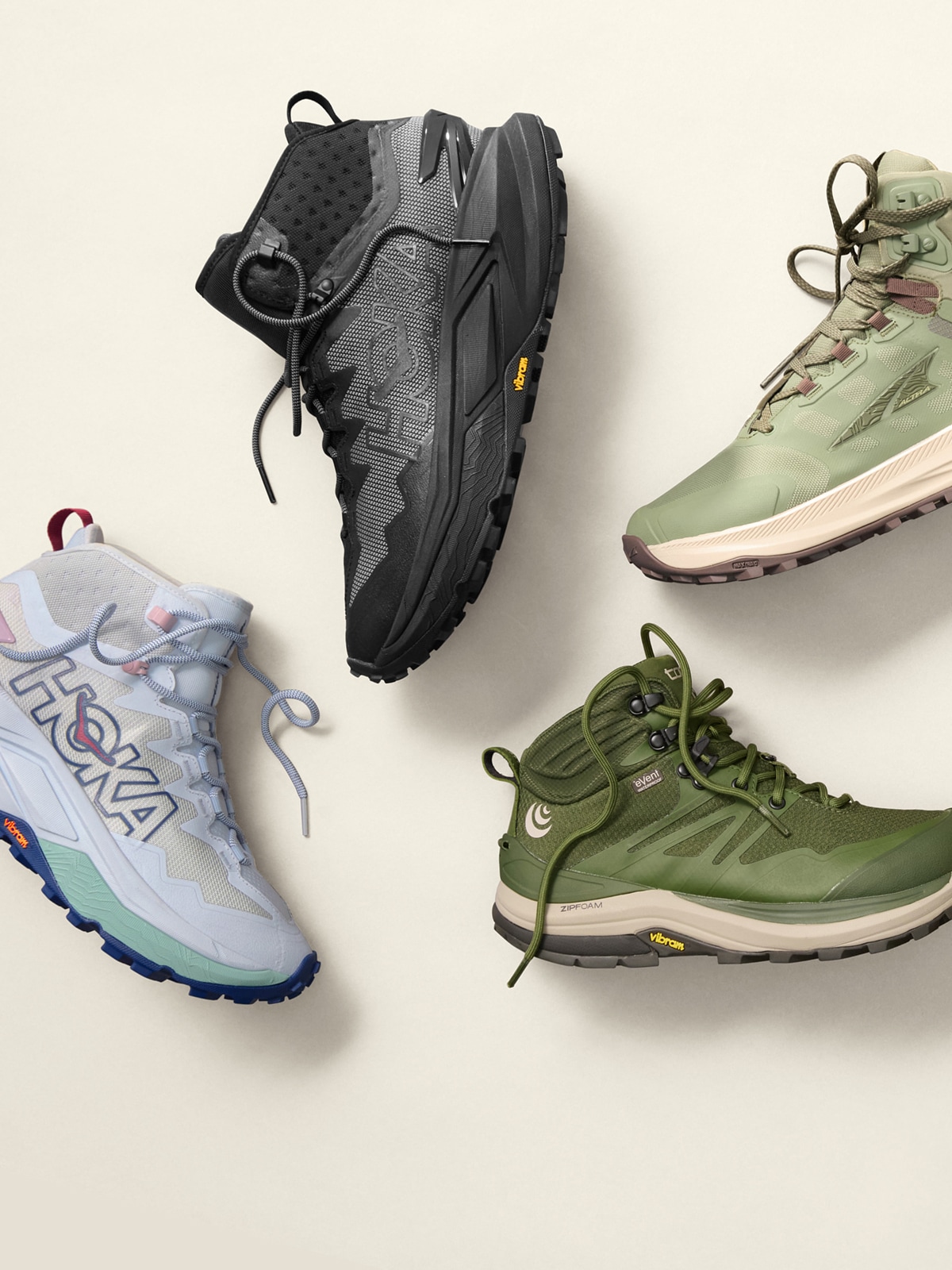 Three people hike over large rocks together.