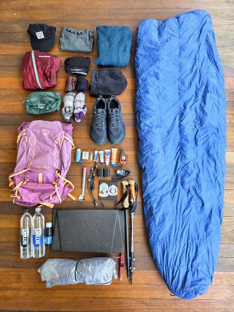 A laydown of gear and apparel from a thru-hiking kit.