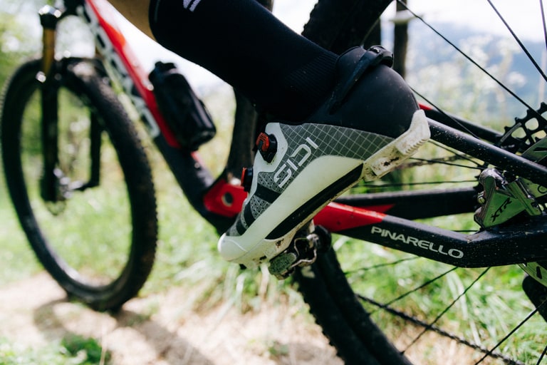 A person wears road cycling shoes while riding.