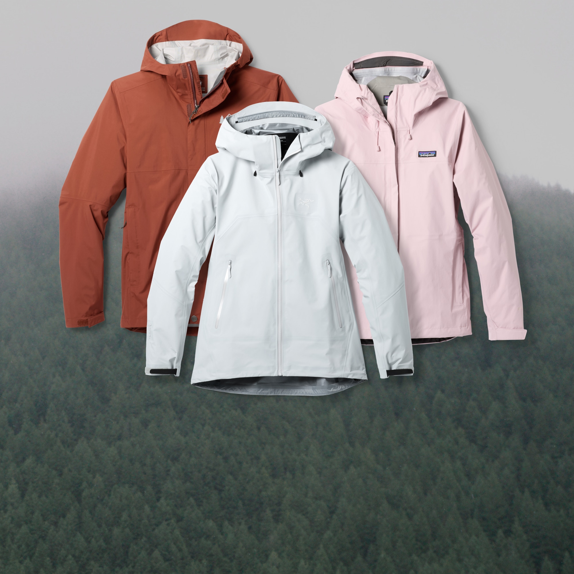 An R E I Co-op rain jacket, a Patagonia rain jacket, and an Arc’teryx rain jacket over an image of fog covered trees.