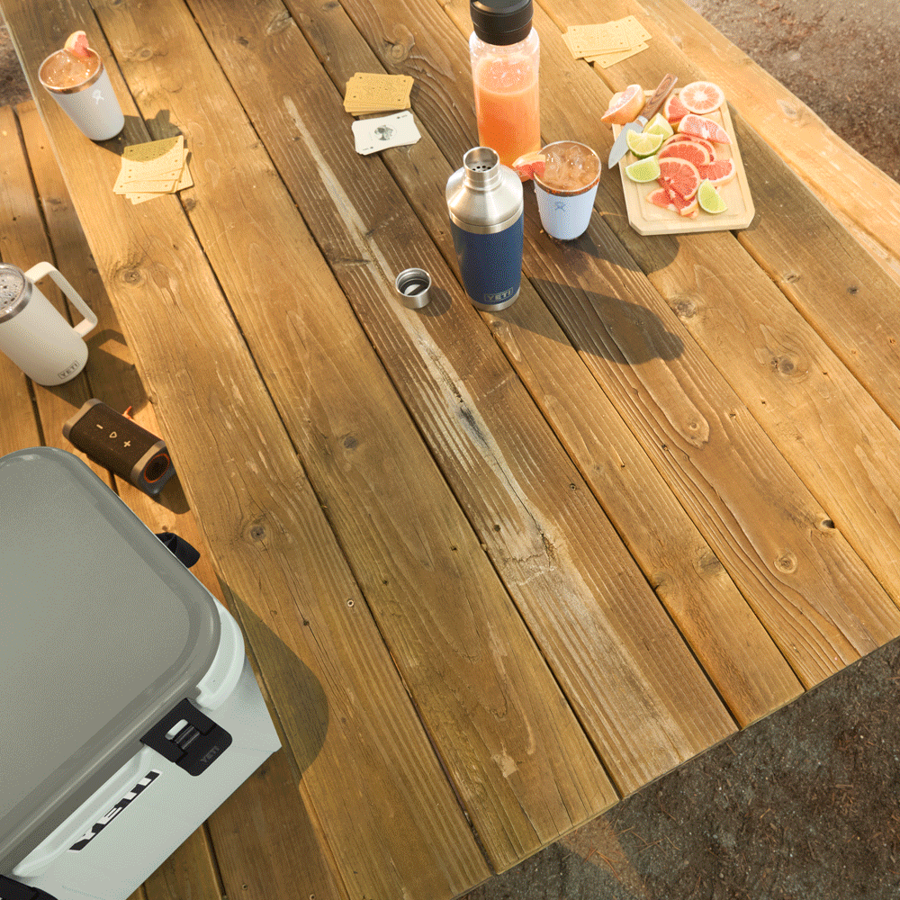 An animated GIF of a table being set and a portable stove being used at a campsite.