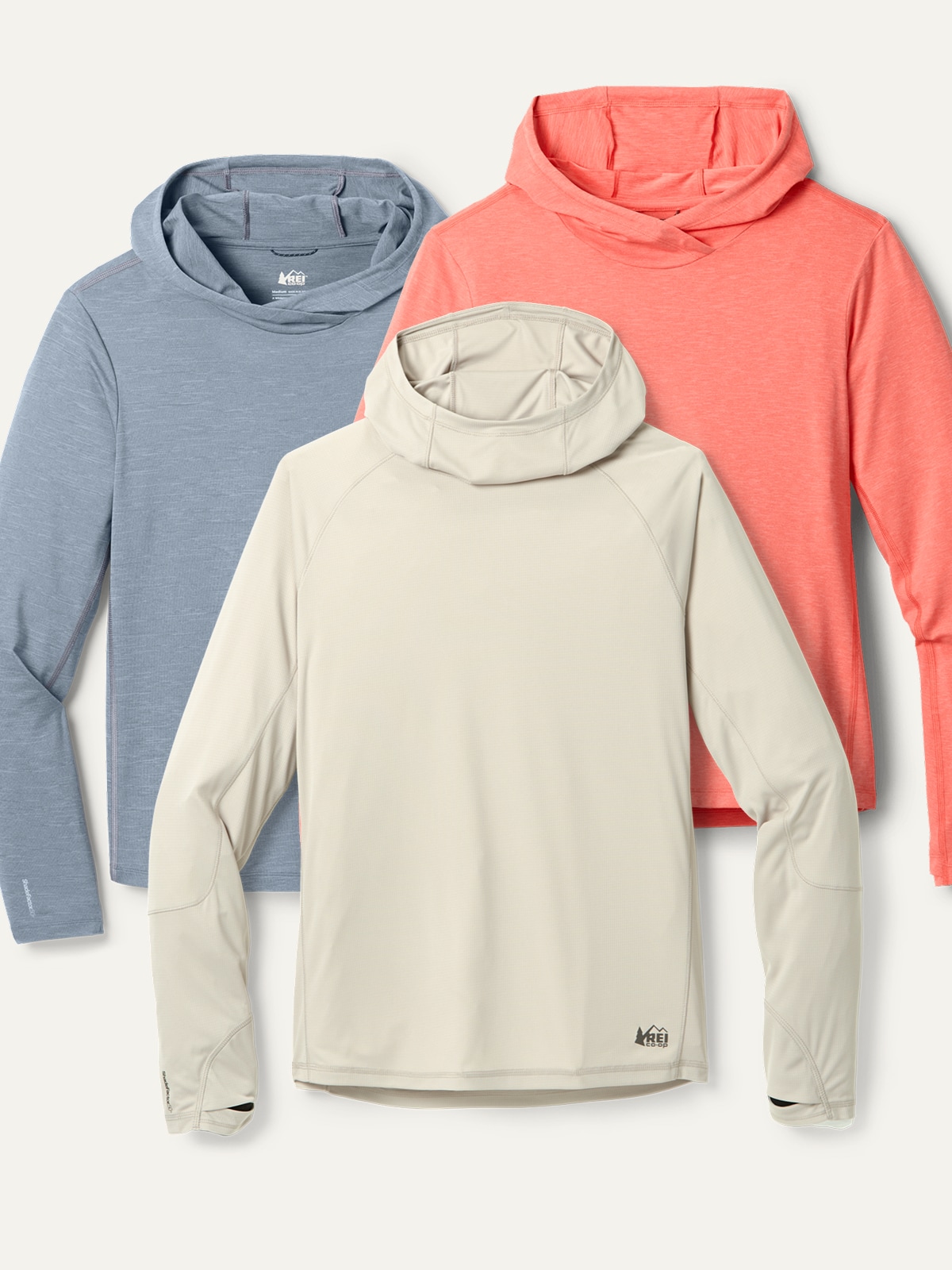 Three long-sleeve UPF shirts on a light colored background.