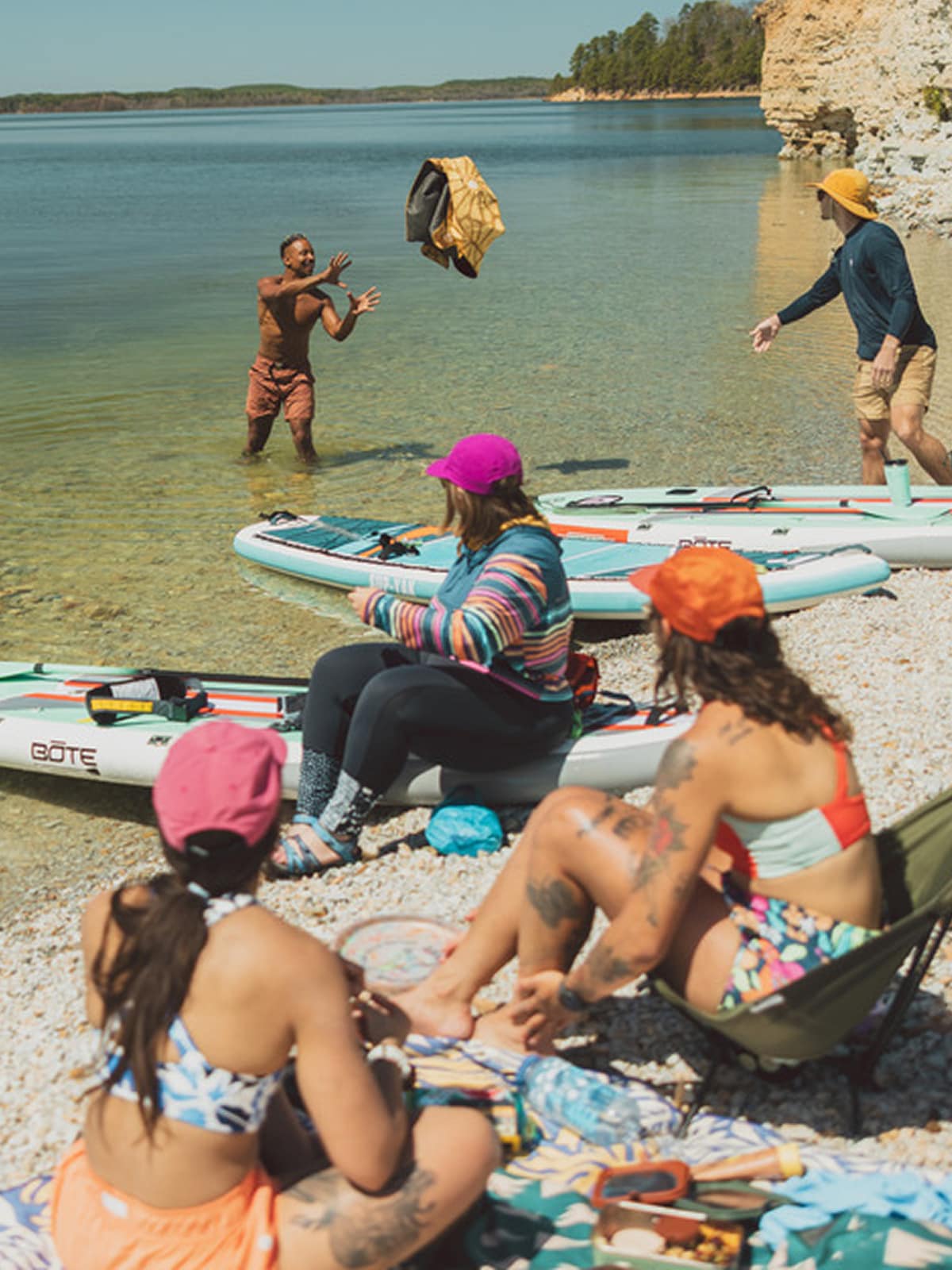 A group of people relax near a lake.