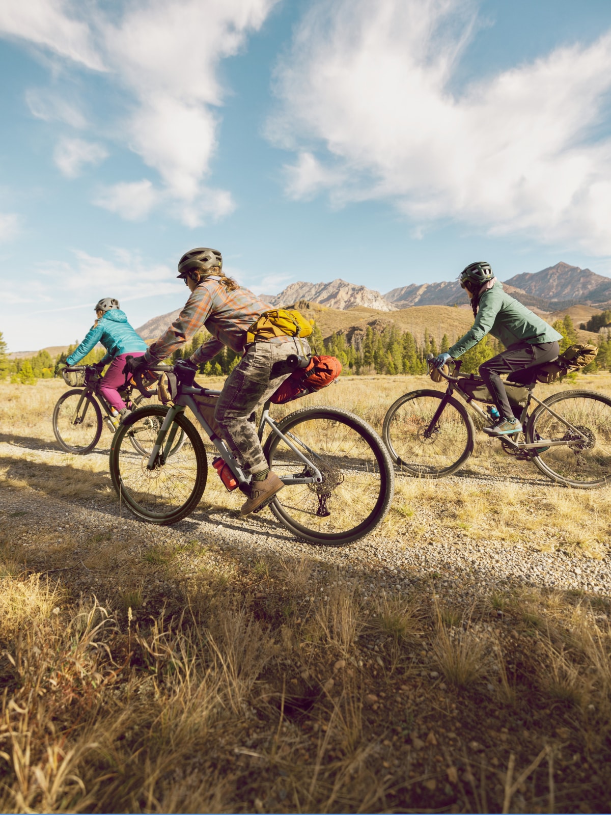 A group of people bike through a gravel trail.