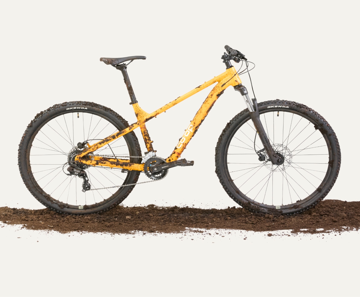 A muddy Co-op Cycles bike on a light colored background.
