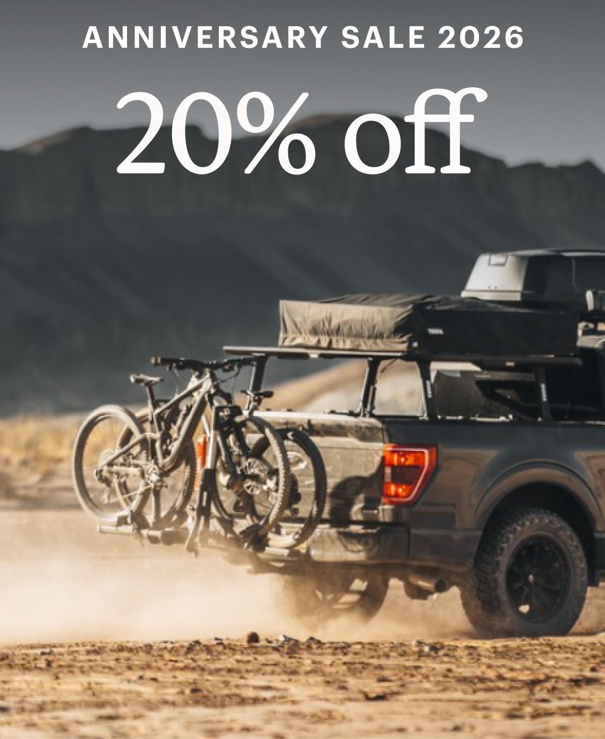 Text reads: ‘Anniversary Sale 2026. 20% off’ over an image of a truck with a roof box and bike rack attached.