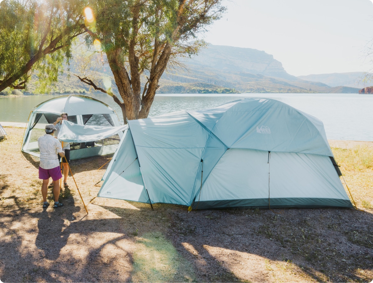 Two people finish putting up their R E I Co-op Westward tent.
