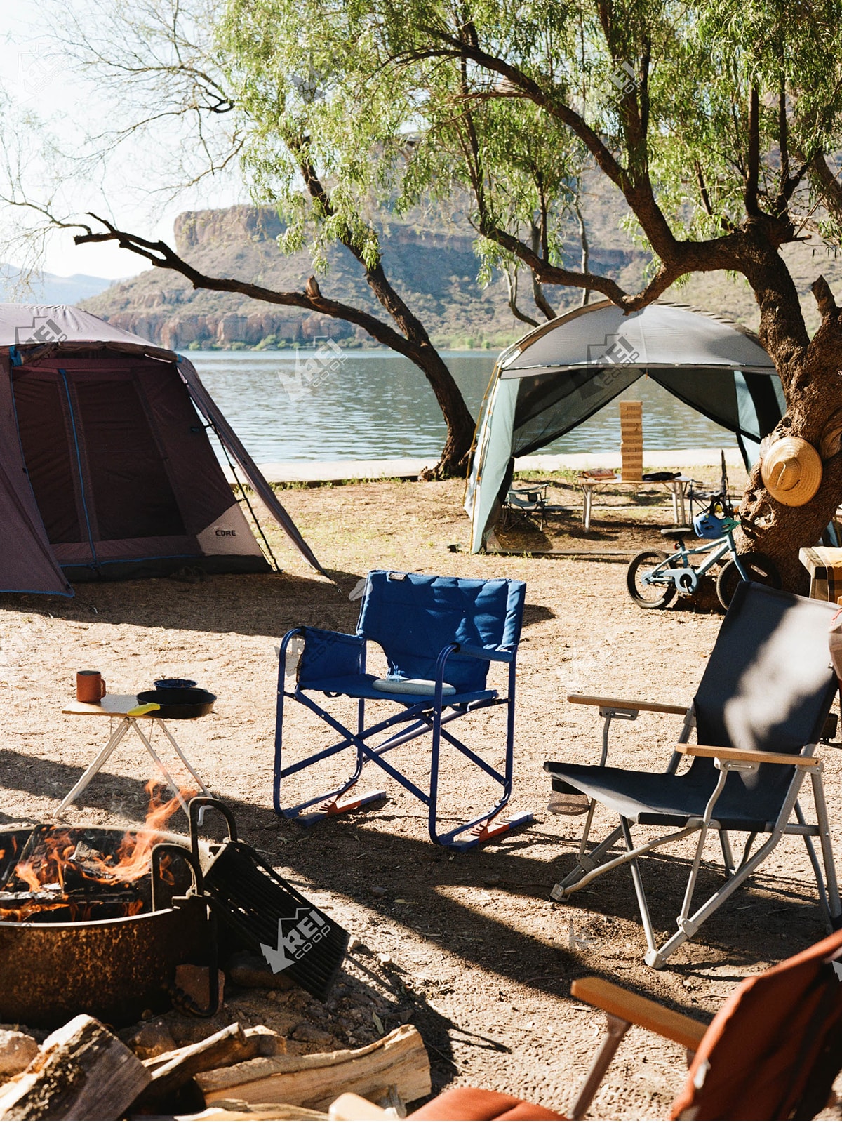 Empty chairs around a fire pit at a campsite.