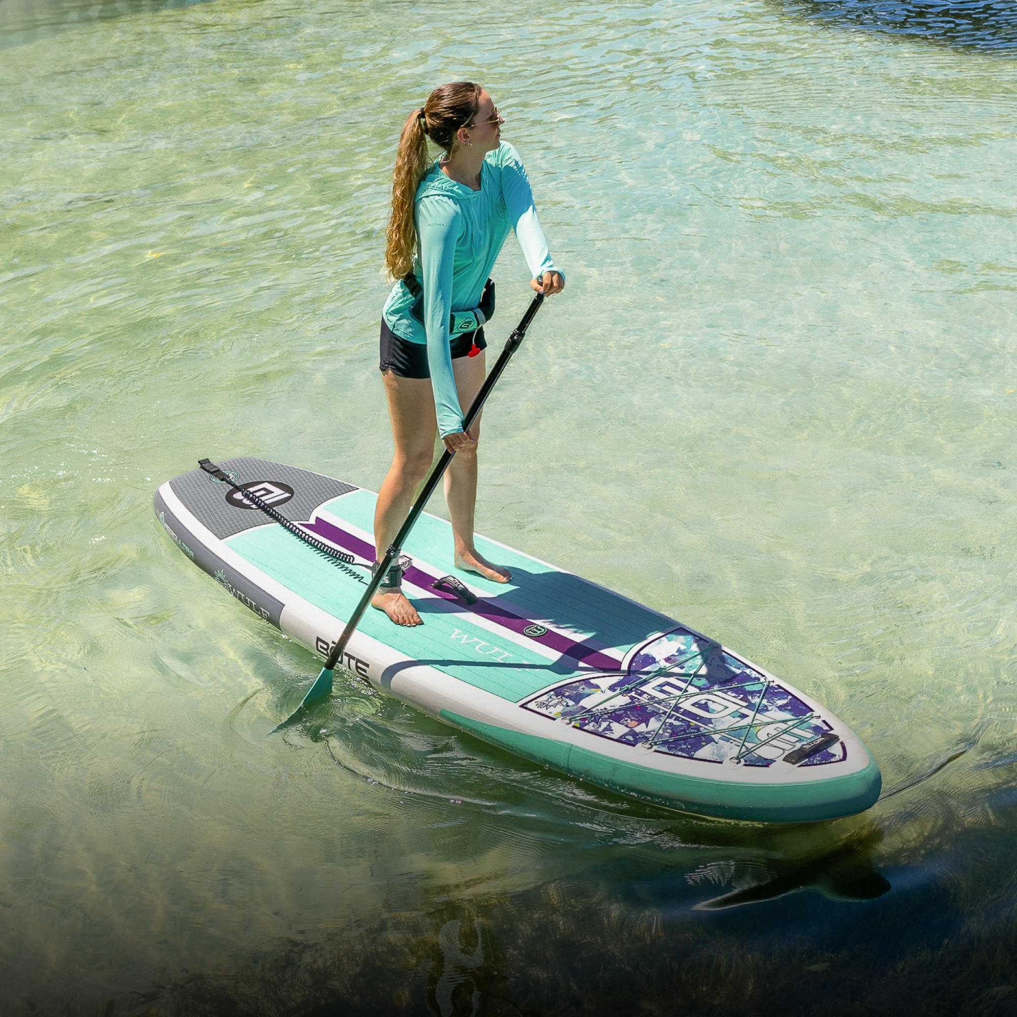 A person moves through a body of water on their BOTE paddle board.