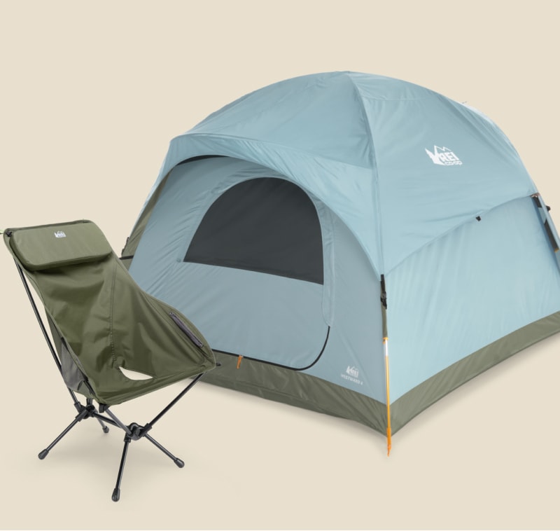 An R E I Co-op brand tent and camp chair on a light colored background.