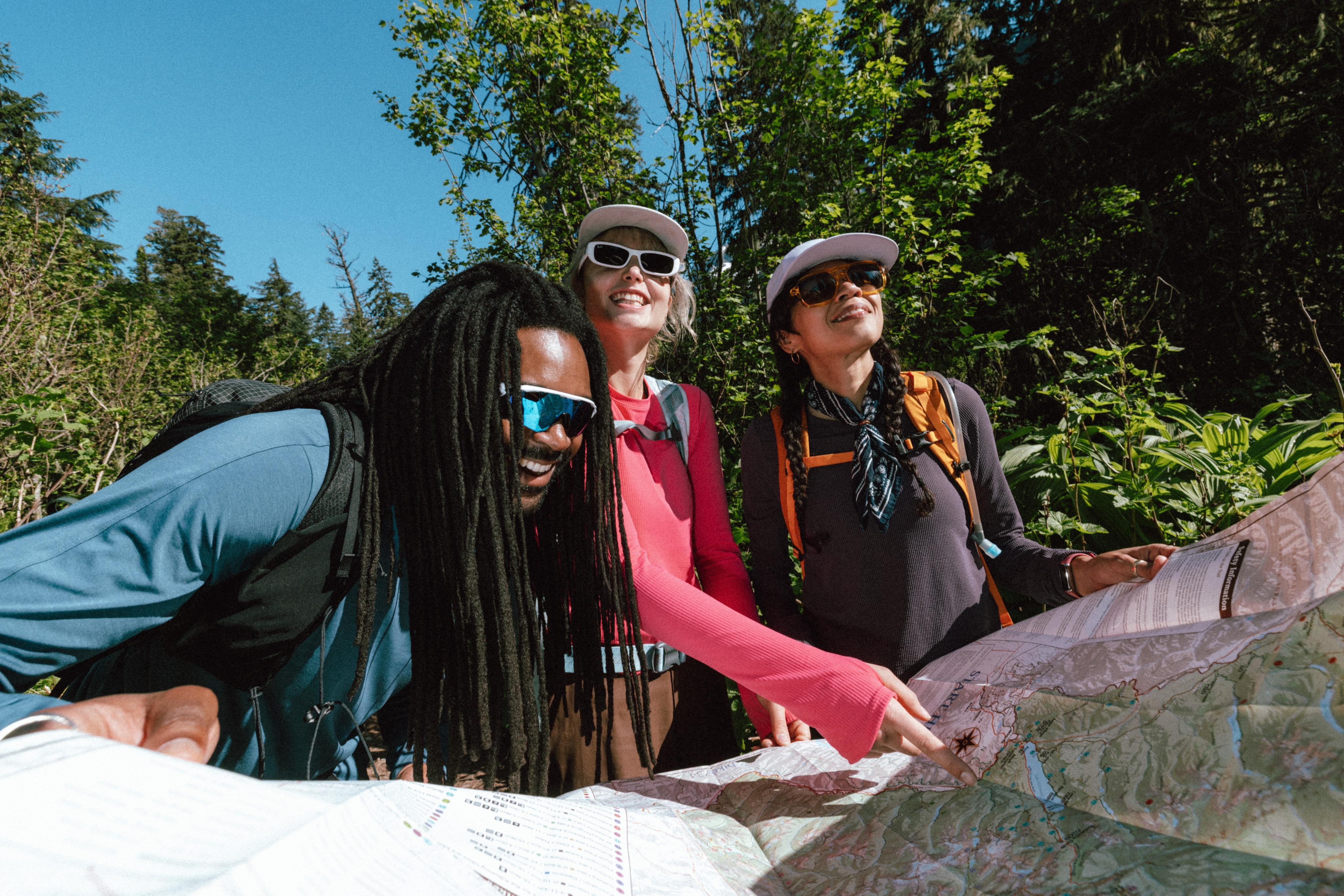 Three hikers look at a paper map