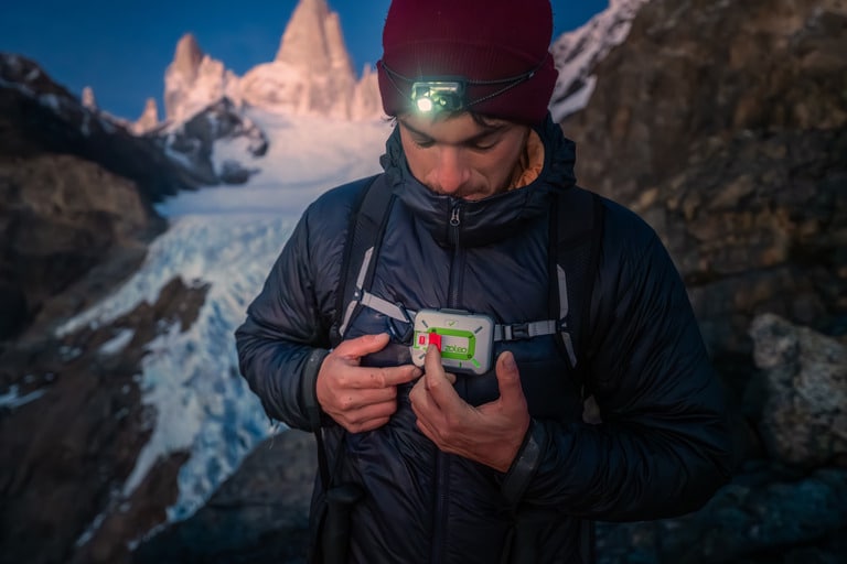 A hiker with a ZOLEO satellite messenger on his chest in a mountain setting