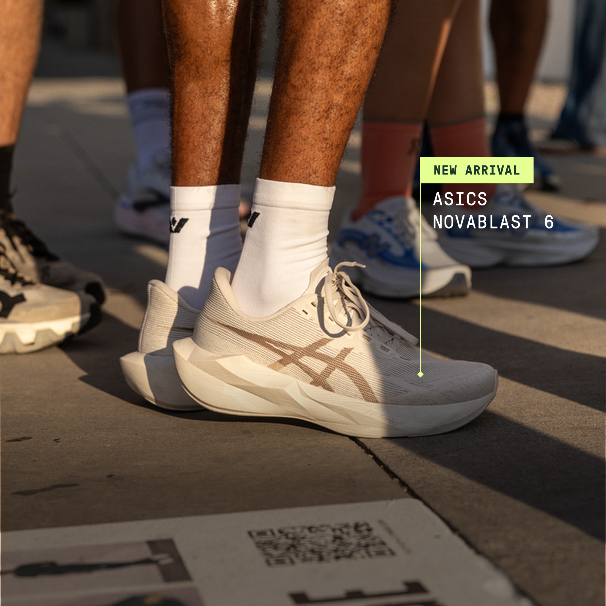 A person standing up in a pair of ASICS Novablast 6 shoes.
