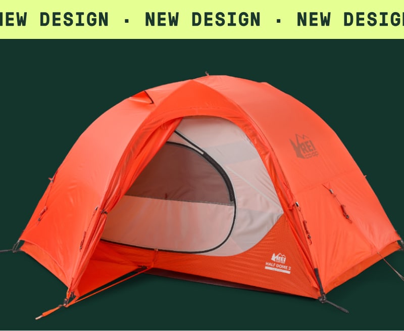 An orange Half Dome 2 All-Season Tent on a green background. Ticker tape text reads: ‘New design.’