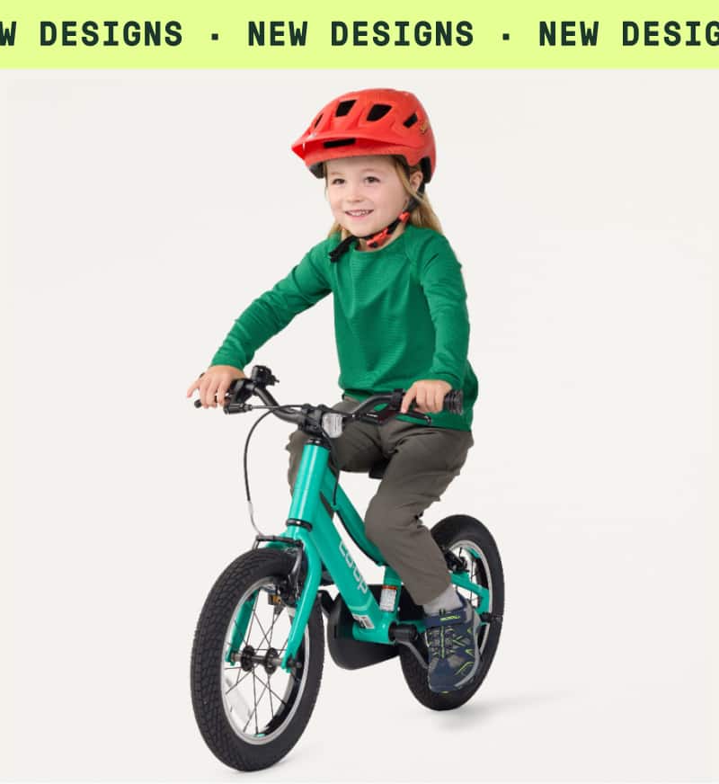 An image of a child riding a Co-op Cycles bike on a light colored background. Ticker tape text reads: ‘New designs.’