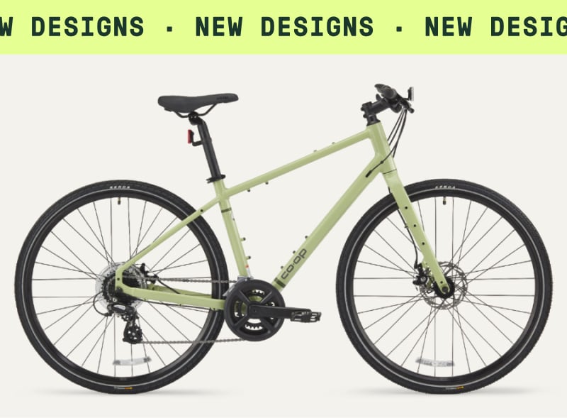 A Co-op Cycles CTY 1.1 Bike on a light colored background. Ticker tape text reads: ‘New designs.’
