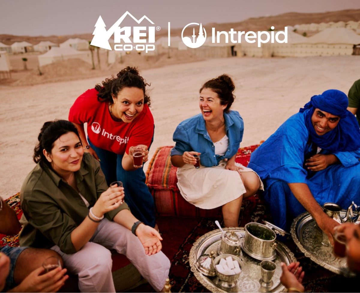 A group of people enjoy drinking tea together while on a trip to Morocco.