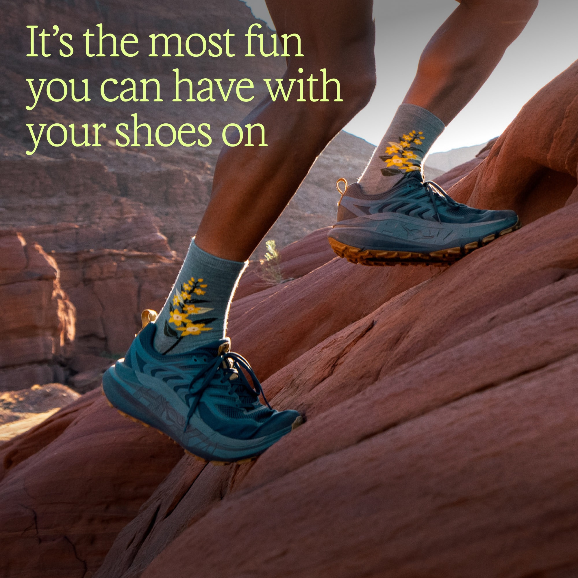 Text reads: ‘It’s the most fun you can have with your shoes on’ over an image of a person running up a steep rock in their HOKA Stinson 8 shoes.