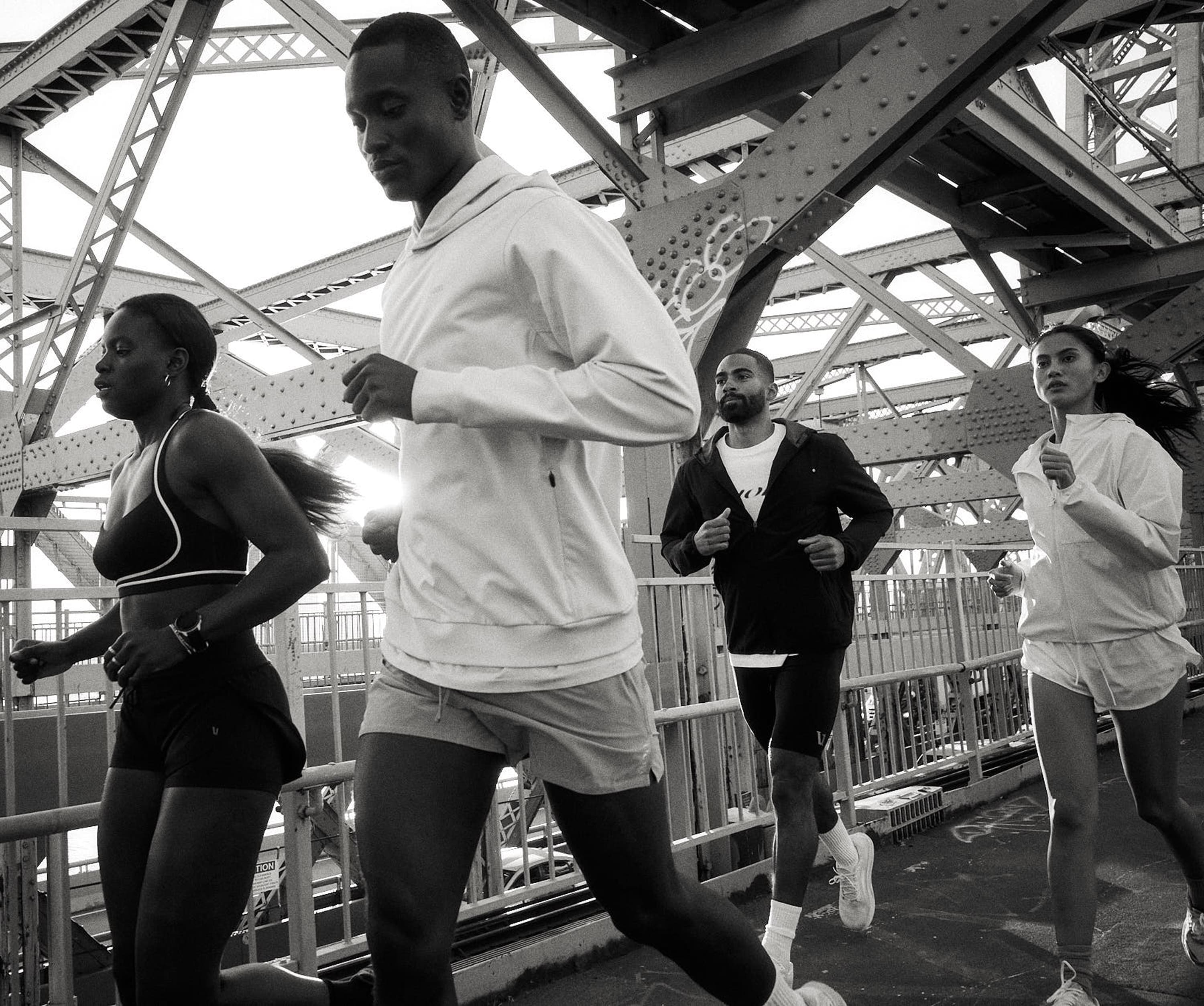A group of people running across a bridge together.
