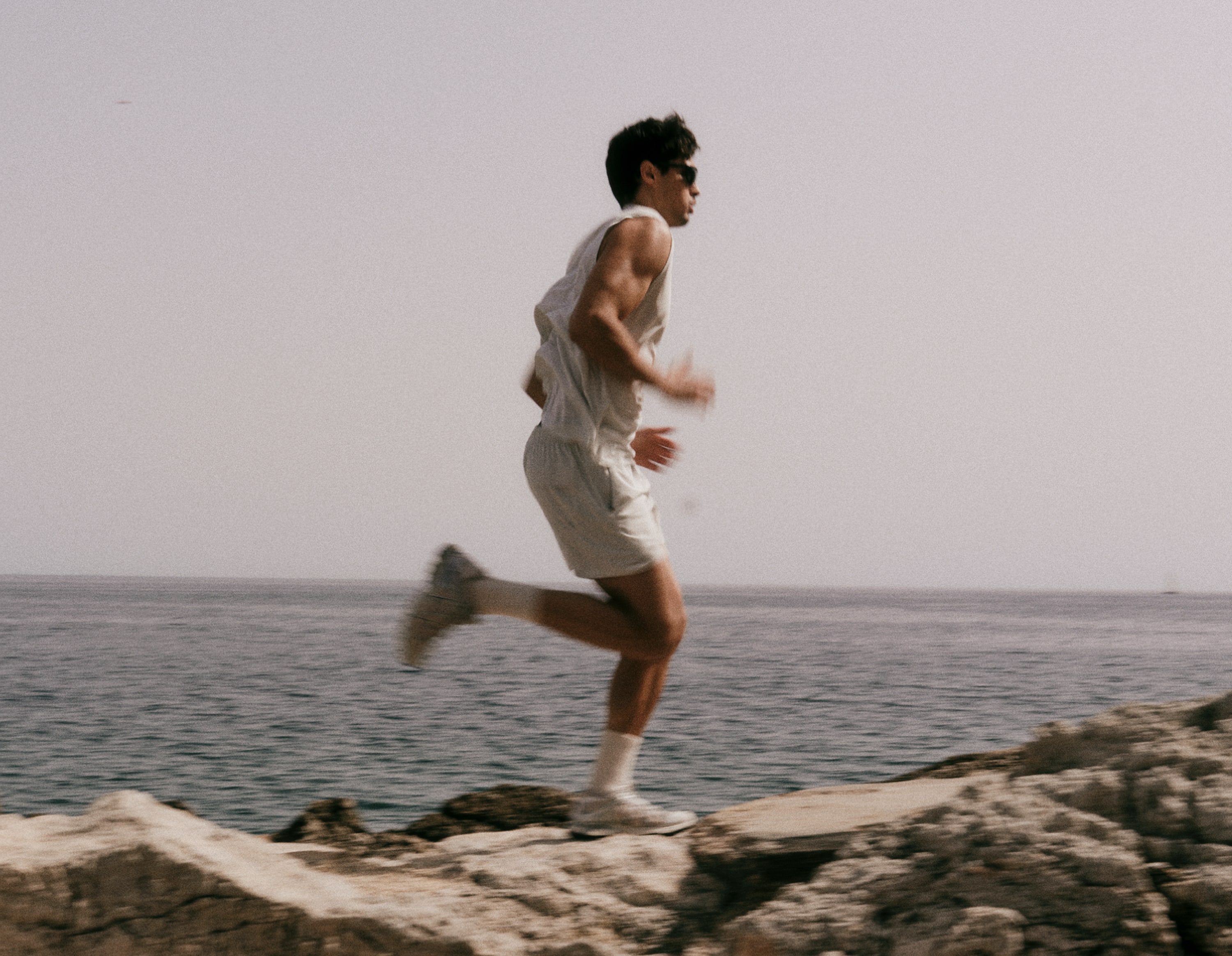 A person runs through a path near a large body of water.