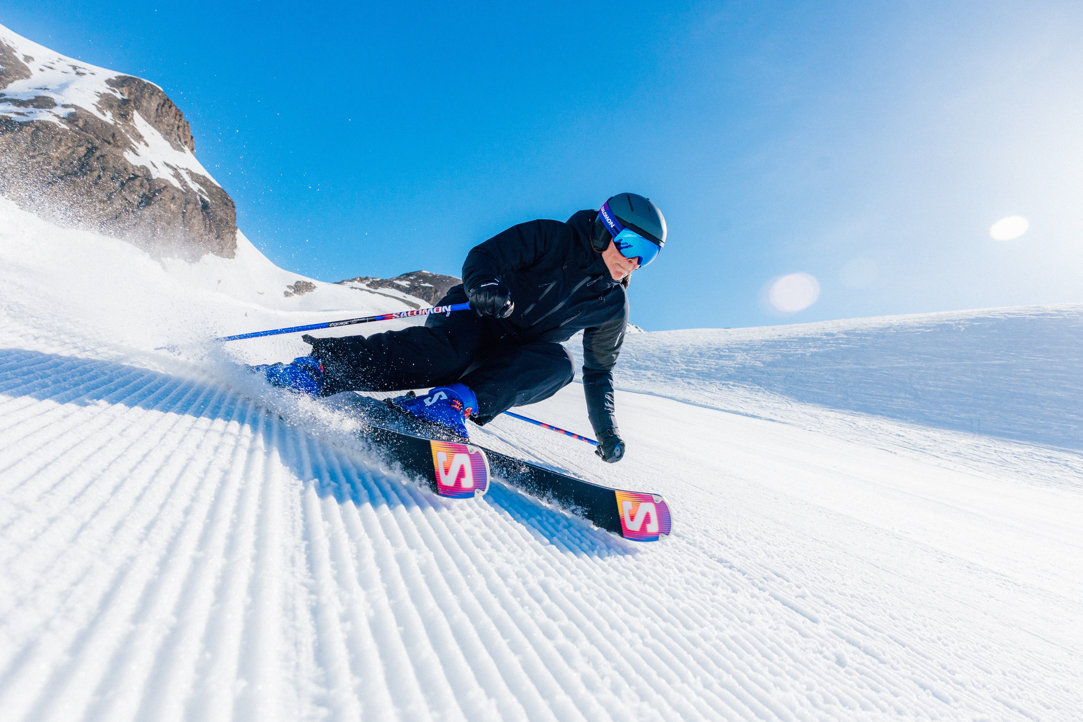 A person speeds downhill on their Salomon skis.