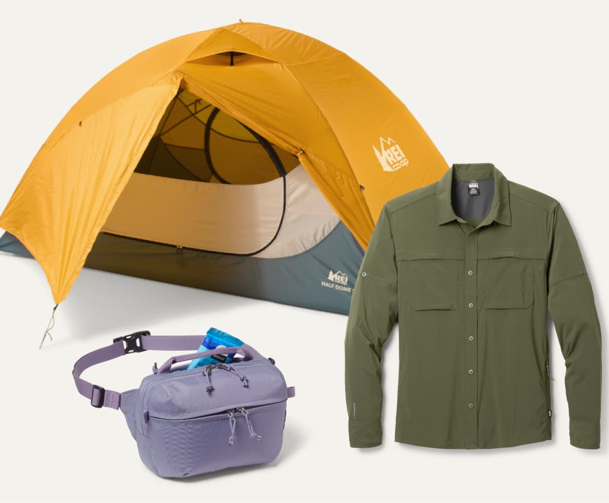 An R E I Co-op brand tent, waist pack, & long-sleeve shirt on a light colored background.
