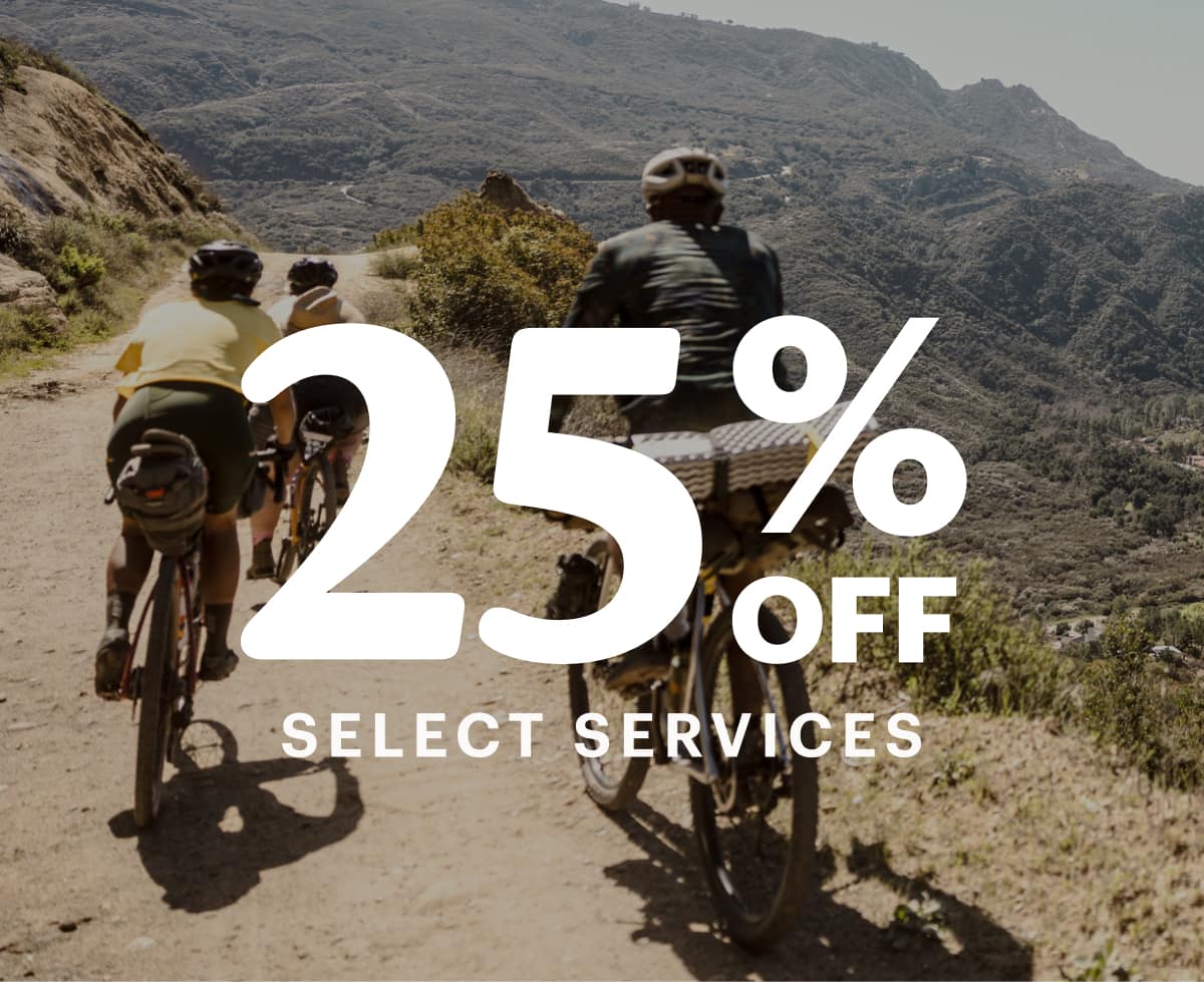 Text reads: ‘25% off select services’ over an image of three people riding bikes through a dirt trail.