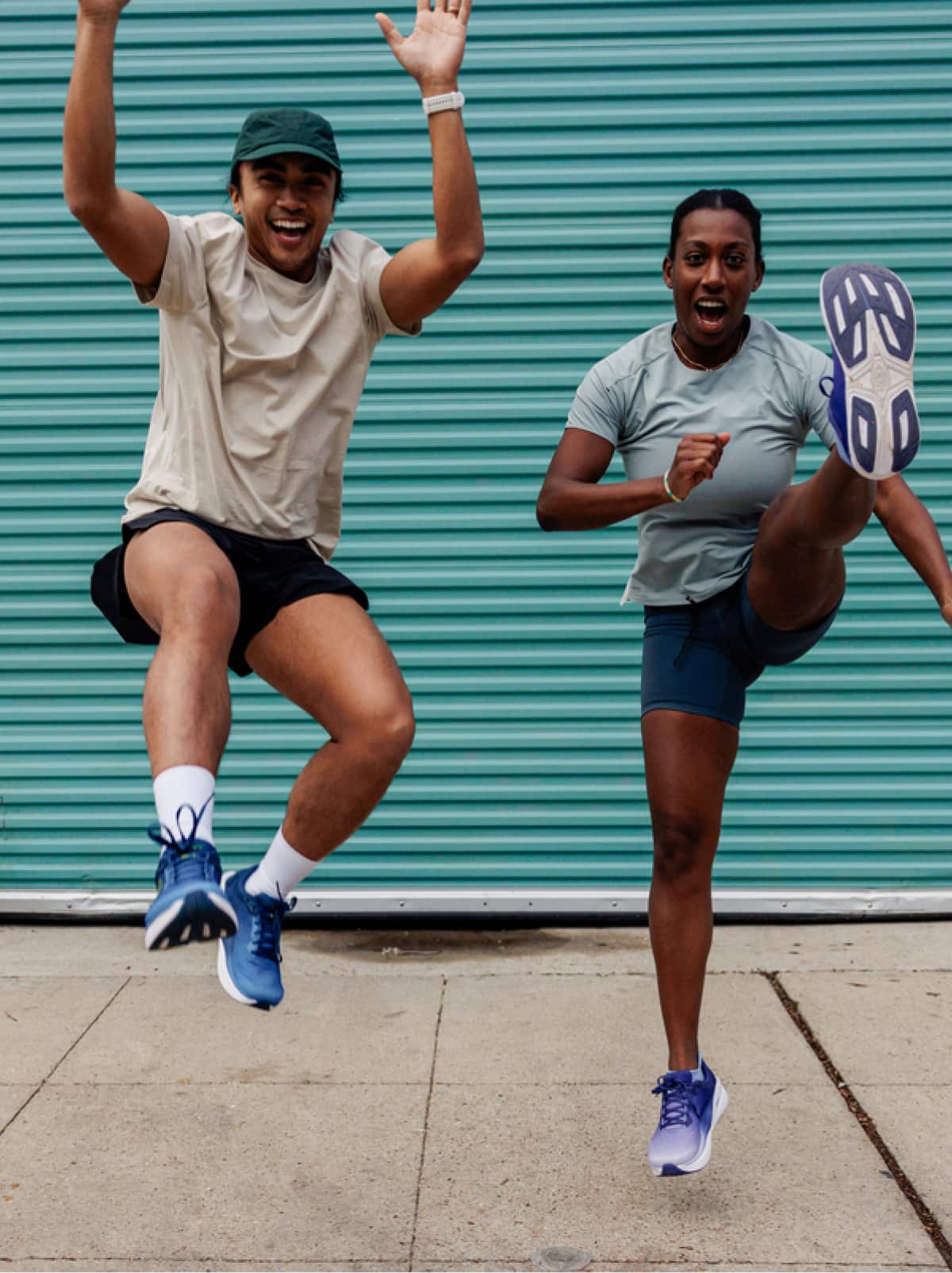 Two people jump and laugh for the camera.