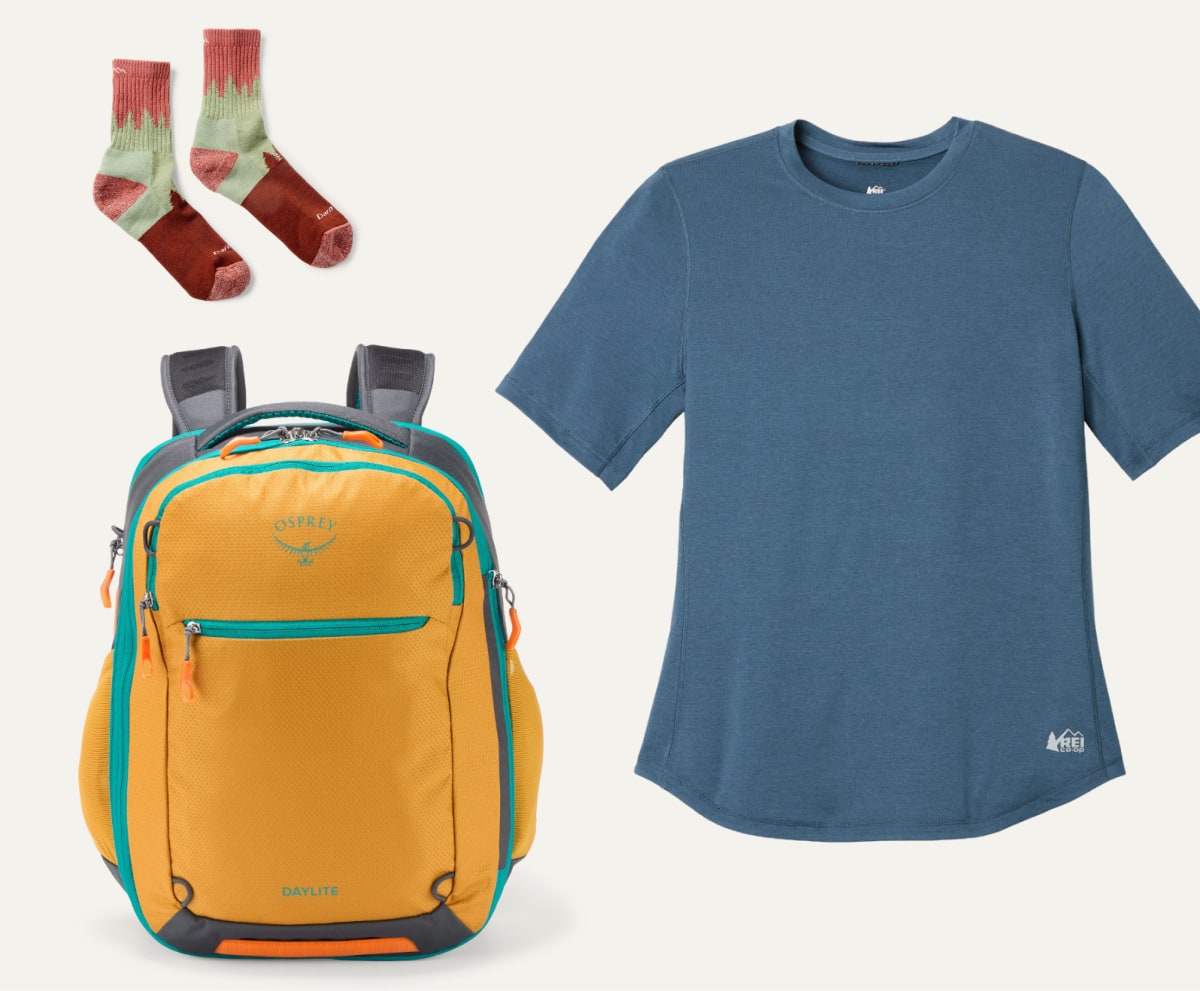 Darn Tough socks, an R E I Co-op brand shirt, & an Osprey pack on a light colored background.