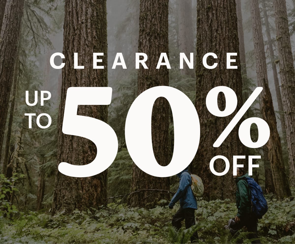 Text reads: ‘Up to 50% off’ over a photo of two people hiking through a forest surrounded by large trees.