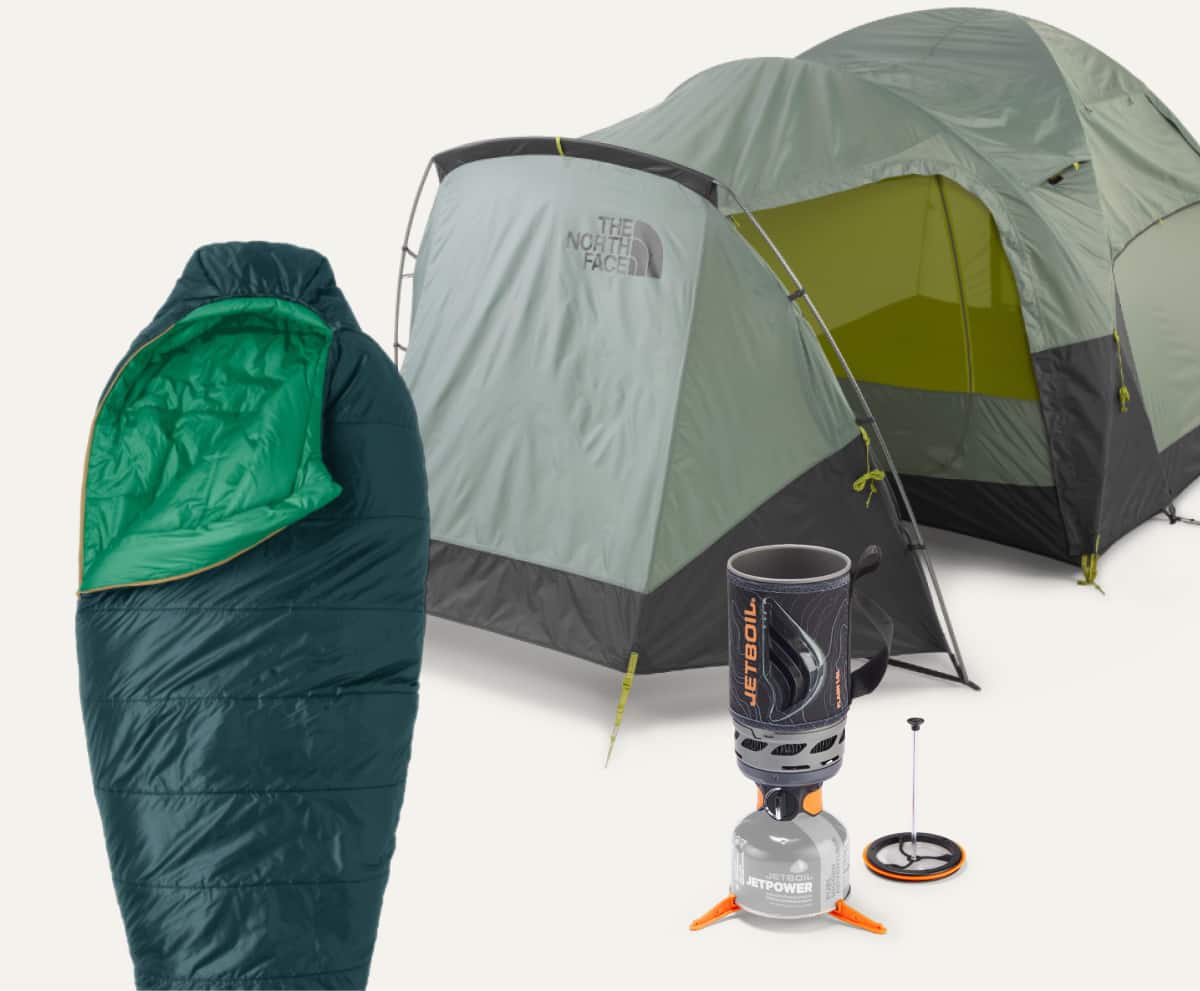 A sleeping bag, tent, & Jet Boil system on a light colored background.