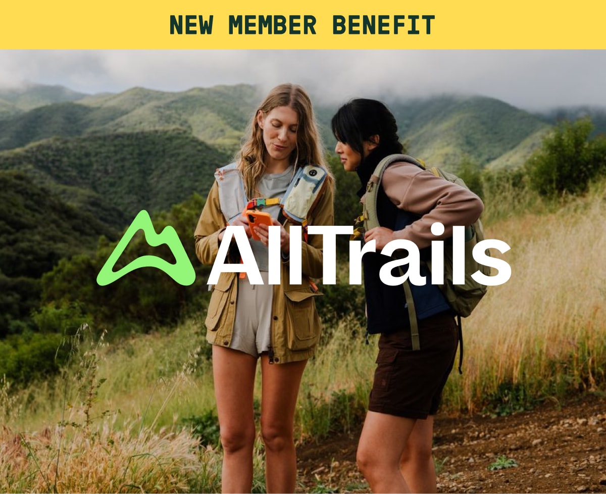 Text reads: ‘AllTrails’ over an image of two hikers looking at a cellphone.