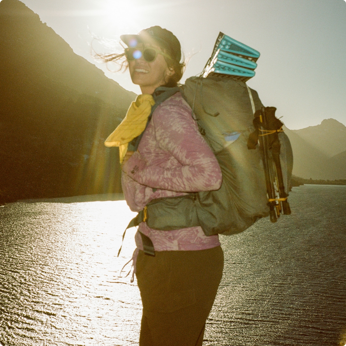 A person poses for the camera with their backpacking gear on. 