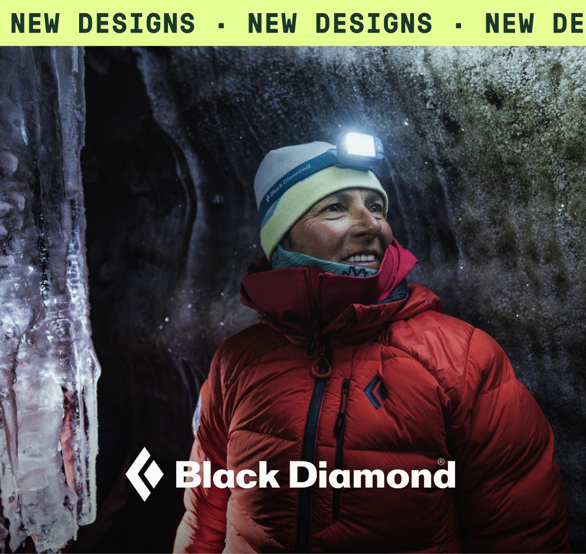 A person bundled up in winter clothing smiles for the camera with a Black Diamond headlamp on.