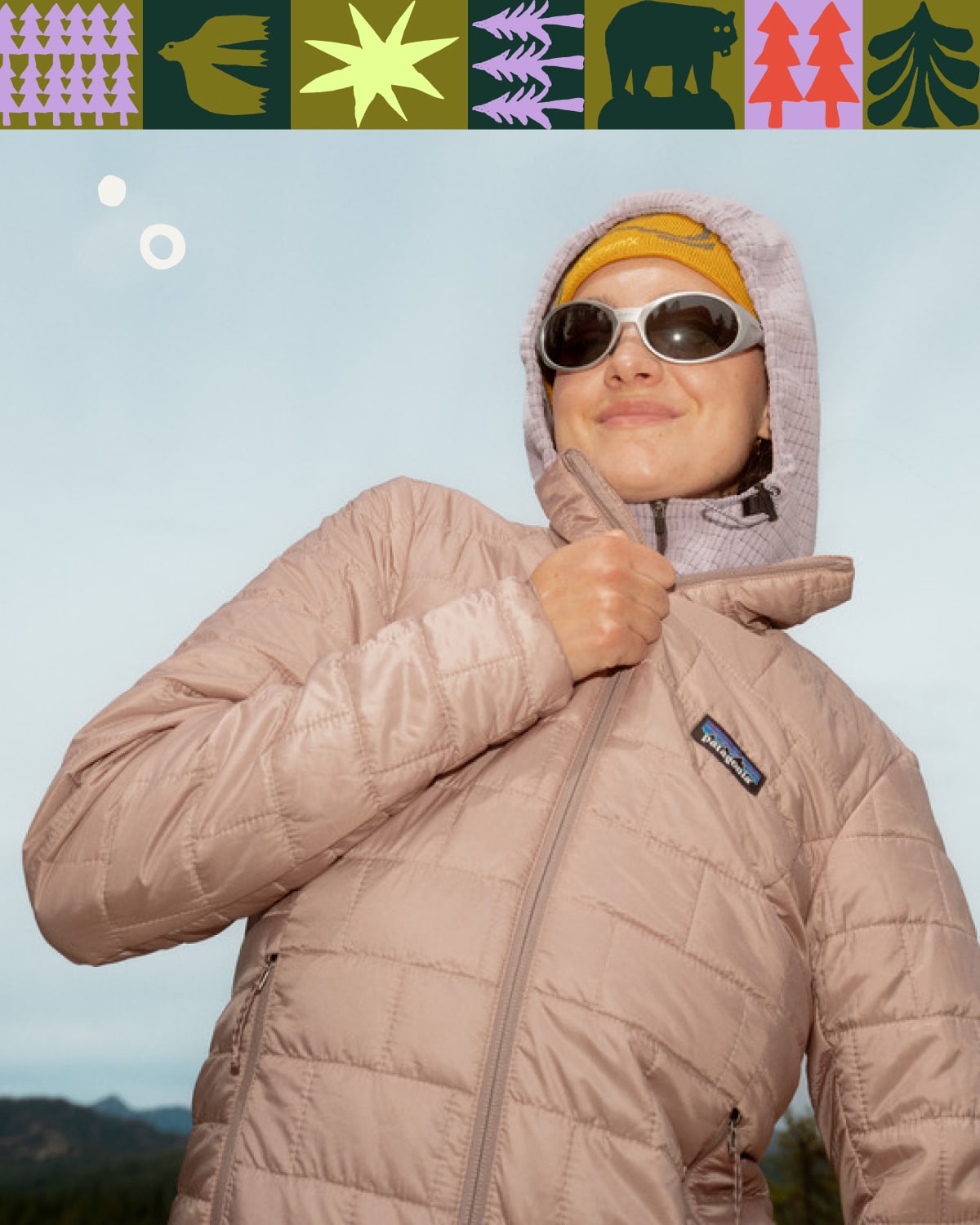 A person zips up their Patagonia jacket while on a hike.
