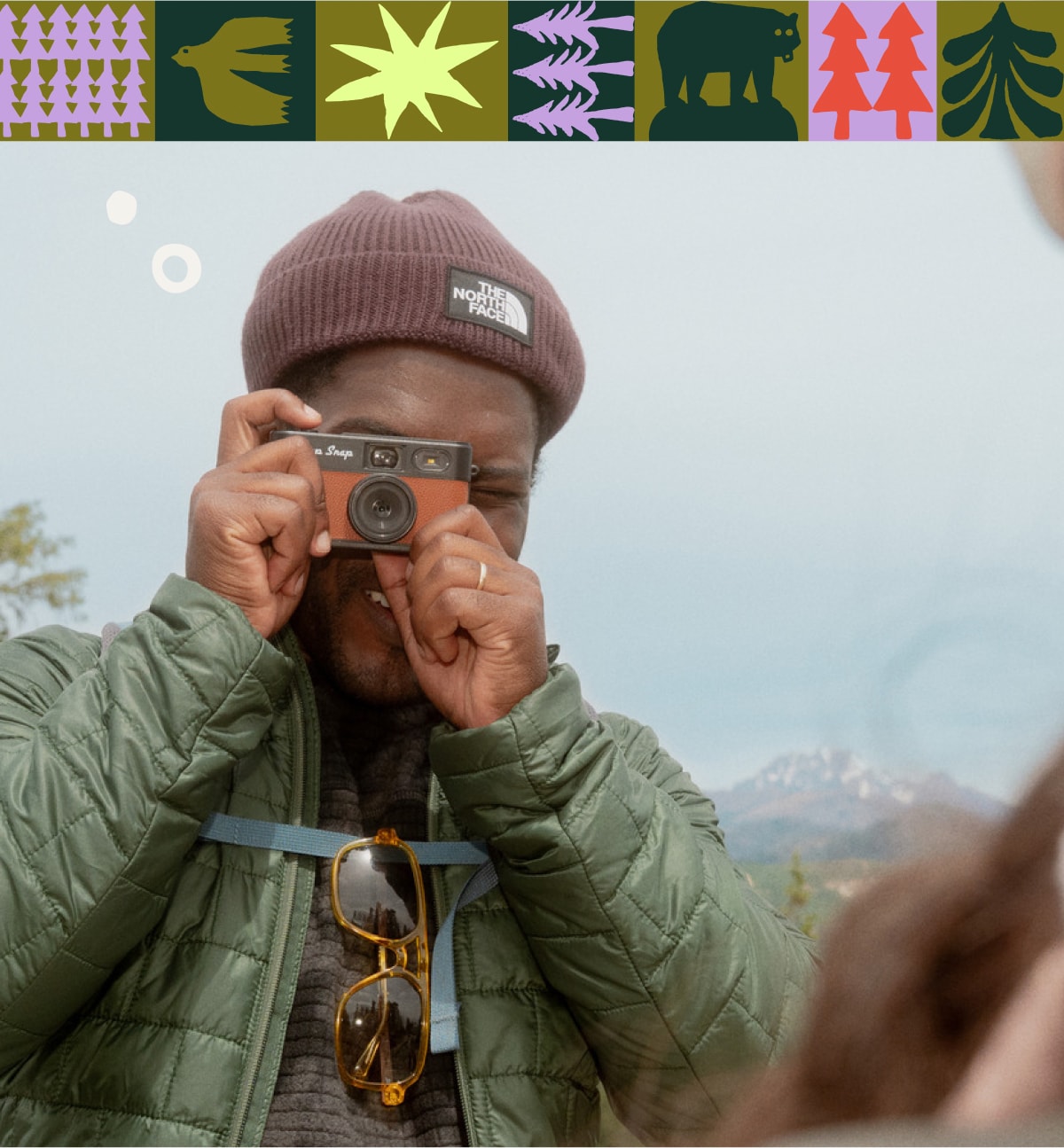 A person takes a photo with their Camp Snap Digital Camera.