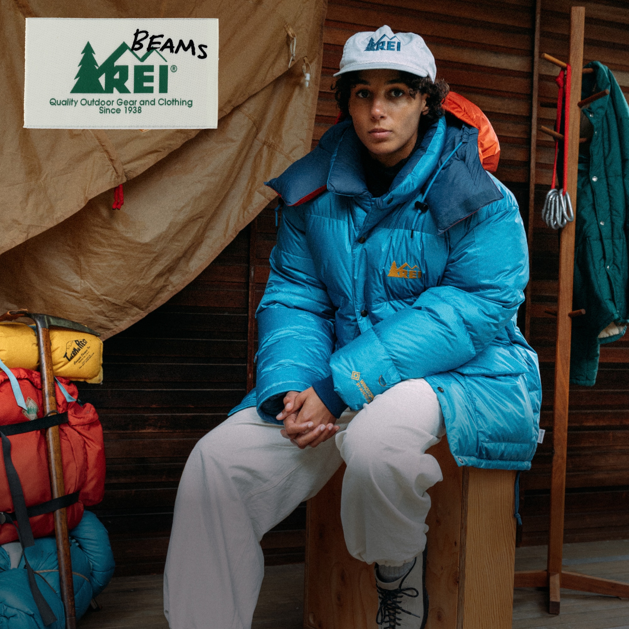 A person sitting down wearing the BEAMS x R E I Co-op Expedition Parka.