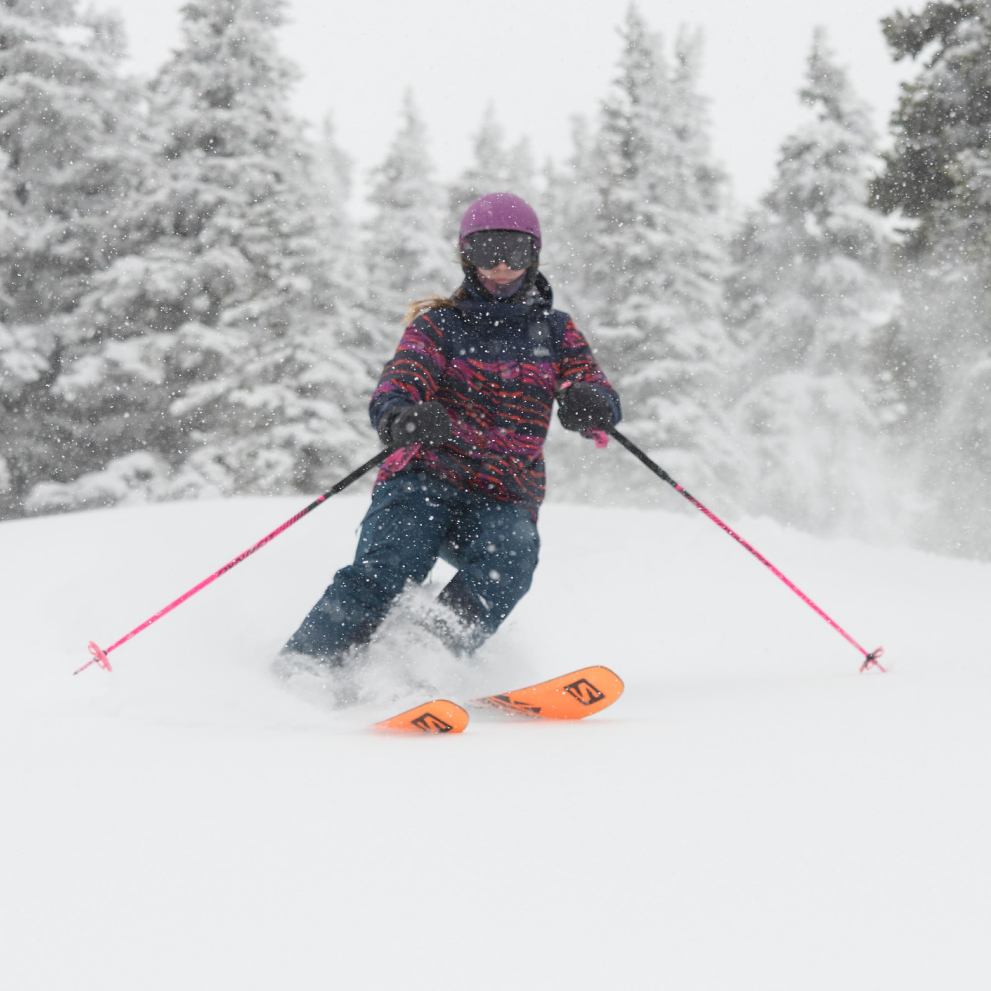 A person skis down a snowy mountain.