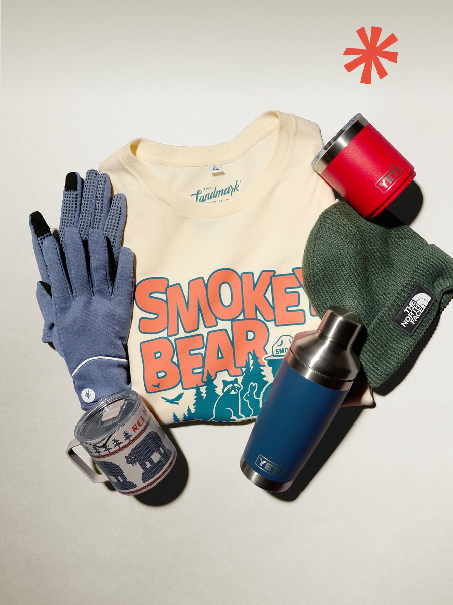 A t-shirt, gloves, a beanie, and drinkware on a light colored background.