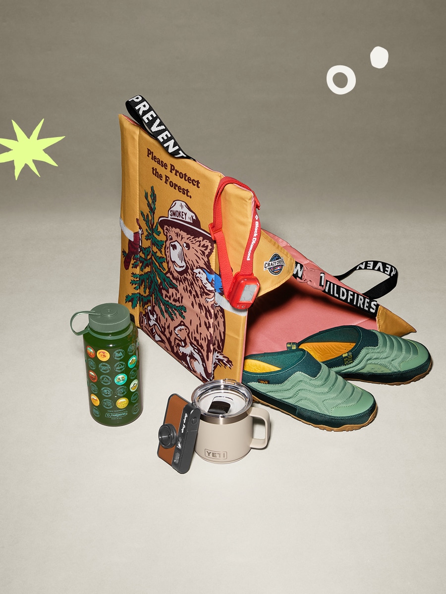 A chair, drinkware, shoes and a camera on a light colored background.