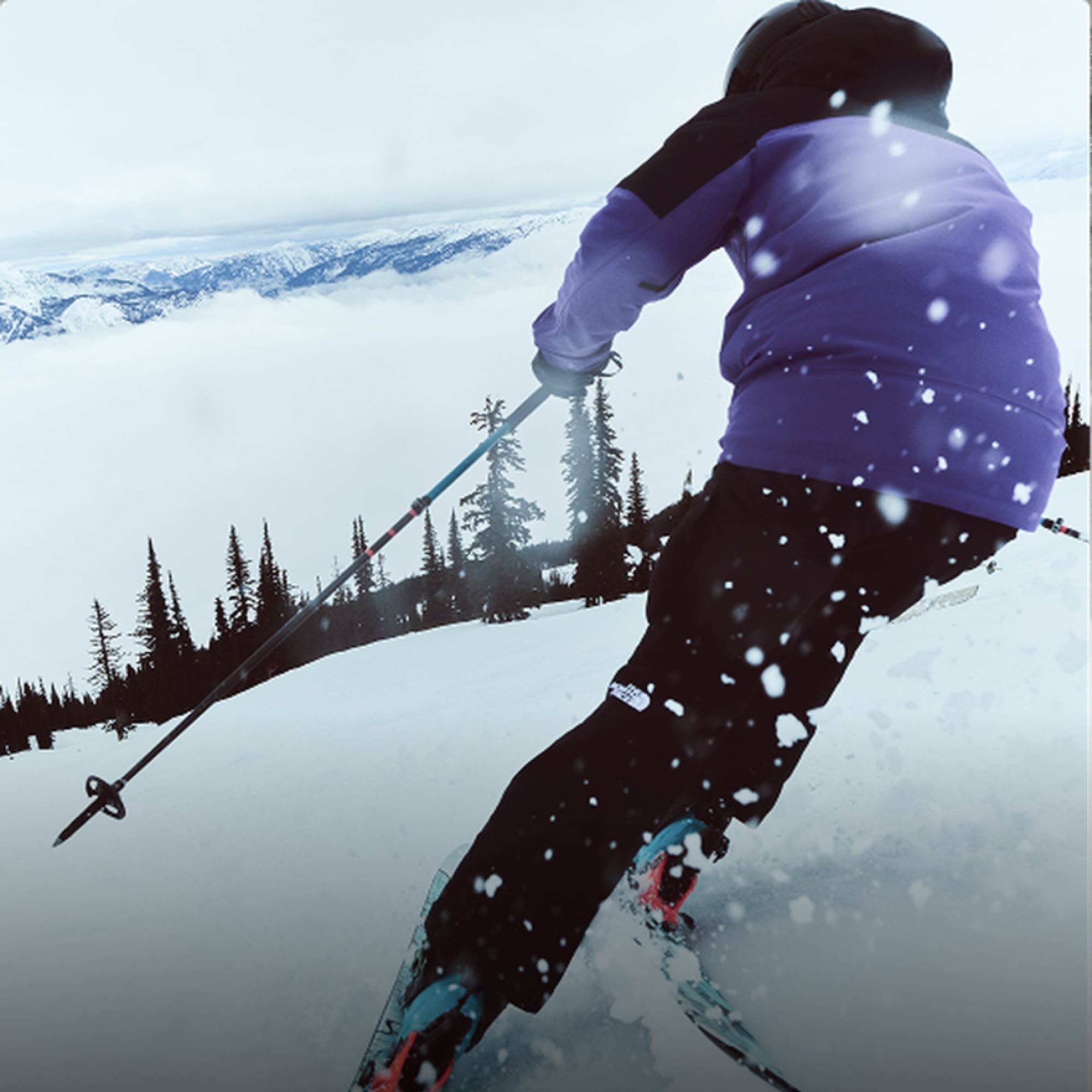 A person skis down a snowy mountain.