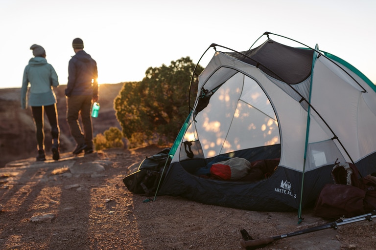 Two campers walk away from their tent at sunrise