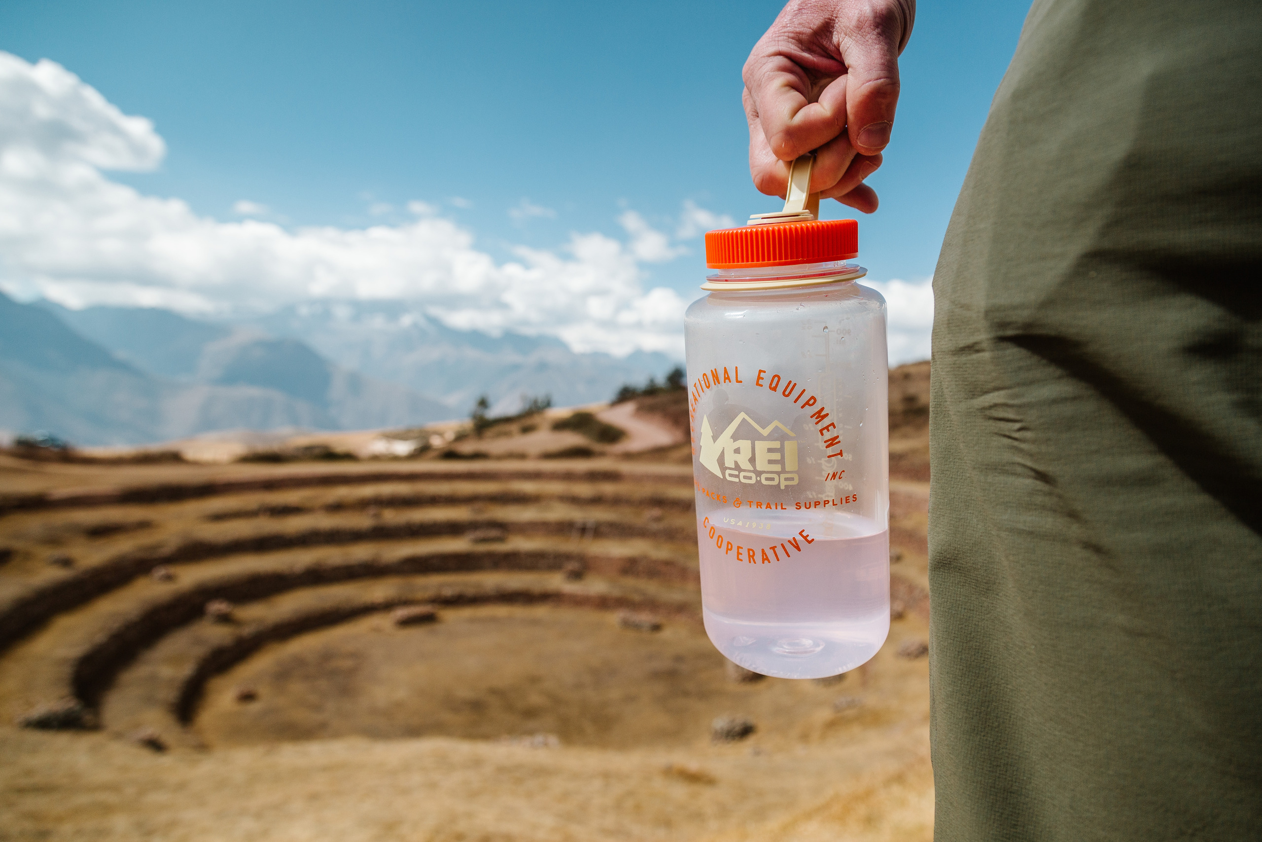 A person carries a Naglen water bottle while on a hike